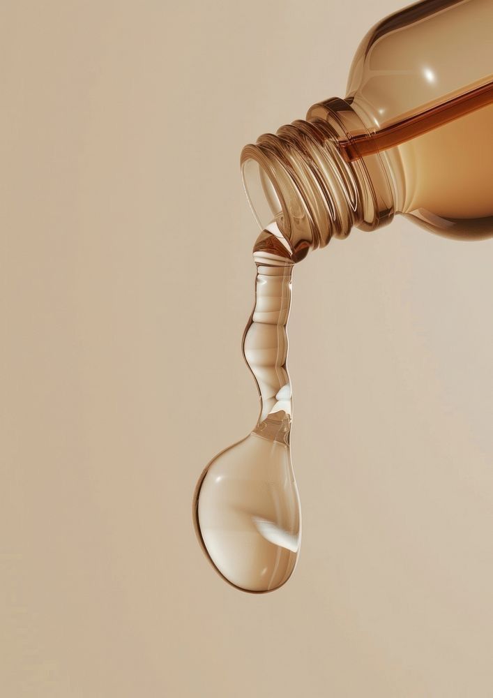Clear serum pouring from an amber bottle